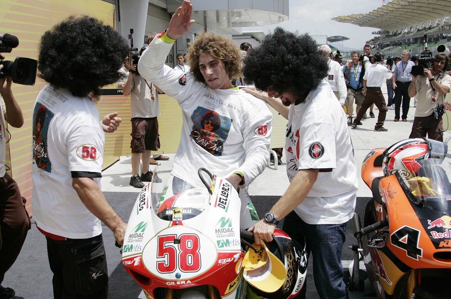 Gli amici accolgono il neo campione del mondo Marco Simoncelli con parrucche che ricordano la sua folta chioma (LaPresse)